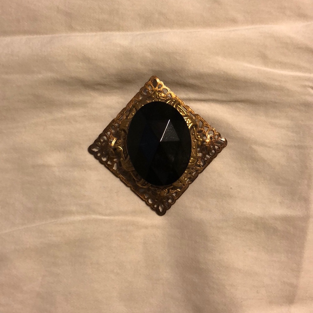 Black jeweled brooch with gold detail